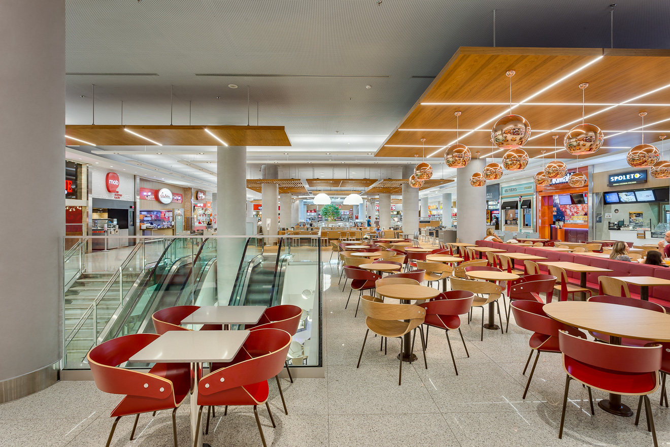 Shopping Mueller, Curitiba. Remodelação da praça de alimentação. A criação de três ambientes com identidades próprias, oferecem maior conforto e diferentes possibilidades de uso ao longo do dia. Destaque para o único ponto de entrada de luz natural que foi marcado com linhas curvas e uma grande jabuticabeira como ponto focal. Projeto premiado na Abrasce 2018 / Expansão e Revitalização. Projetado executado pela espaçonovo arquitetura, empresa especializada em arquitetura de varejo, sediada em São Paulo e qual a arquiteta Jovita Torrano é diretora e fundadora.