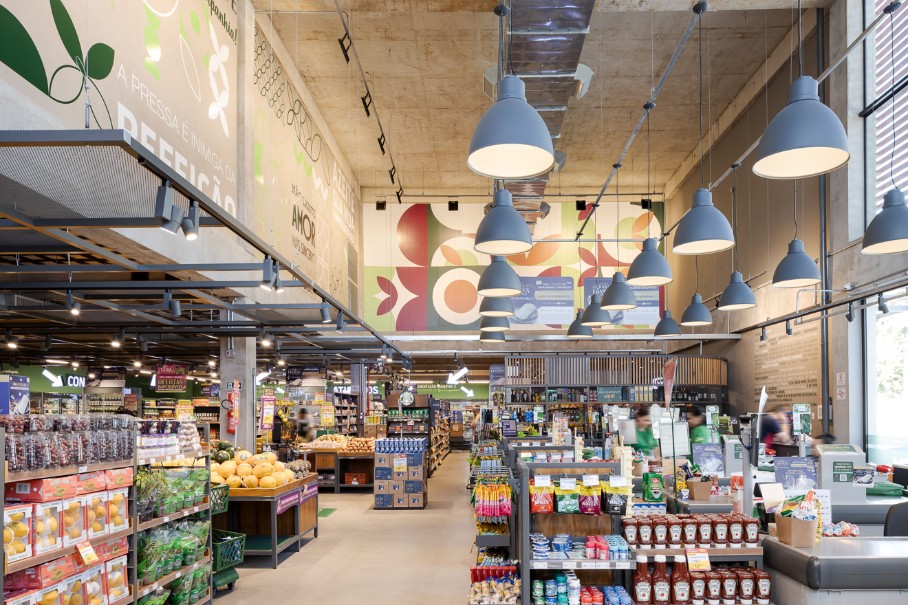 St Marche Supermercado, Litoral Norte de São Paulo, Santos. Projetado executado pela espaçonovo arquitetura, empresa especializada em arquitetura de varejo, sediada em São Paulo e qual a arquiteta Jovita Torrano é diretora e fundadora. Primeira unidade do St Marche Supermercados no litoral Paulista. Projetada dentro do Novo Conceito, prioriza as áreas de Perecíveis, com serviços de Sushi, Café e Pizza no acesso da loja para ser degustado num charmoso deck aberto para a movimentada esquina. A Padaria localizada no mezanino é toda envidraçada se integrando visualmente com a loja.